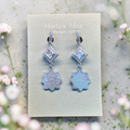 Harlow Mae Designs LLC silver-toned dangle earrings with square-cut cubic zirconia and iridescent celestial bloom charms.