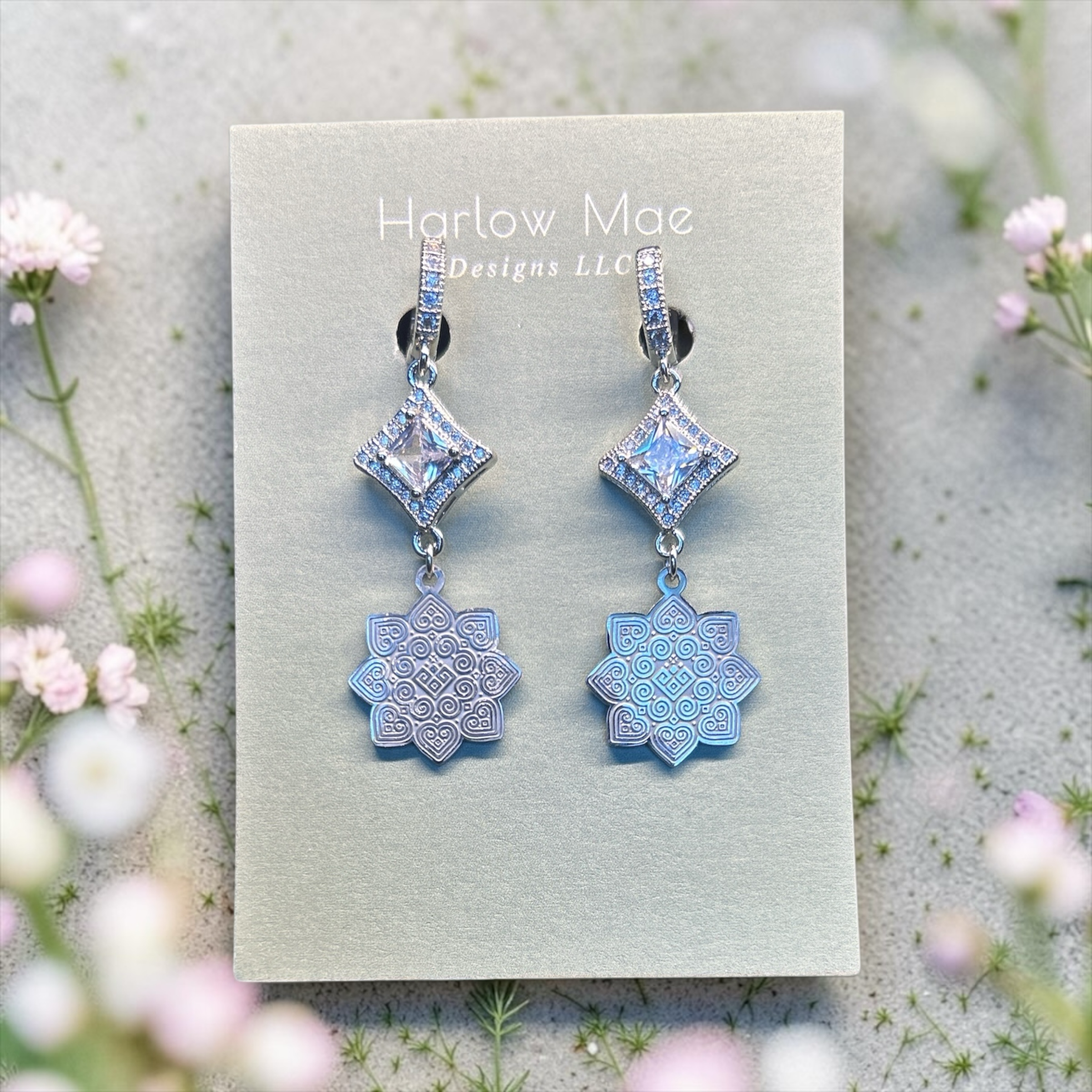 Harlow Mae Designs LLC silver-toned dangle earrings with square-cut cubic zirconia and iridescent celestial bloom charms.