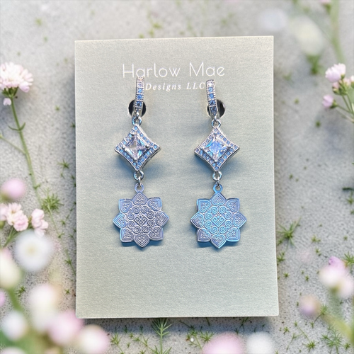 Harlow Mae Designs LLC silver-toned dangle earrings with square-cut cubic zirconia and iridescent celestial bloom charms.