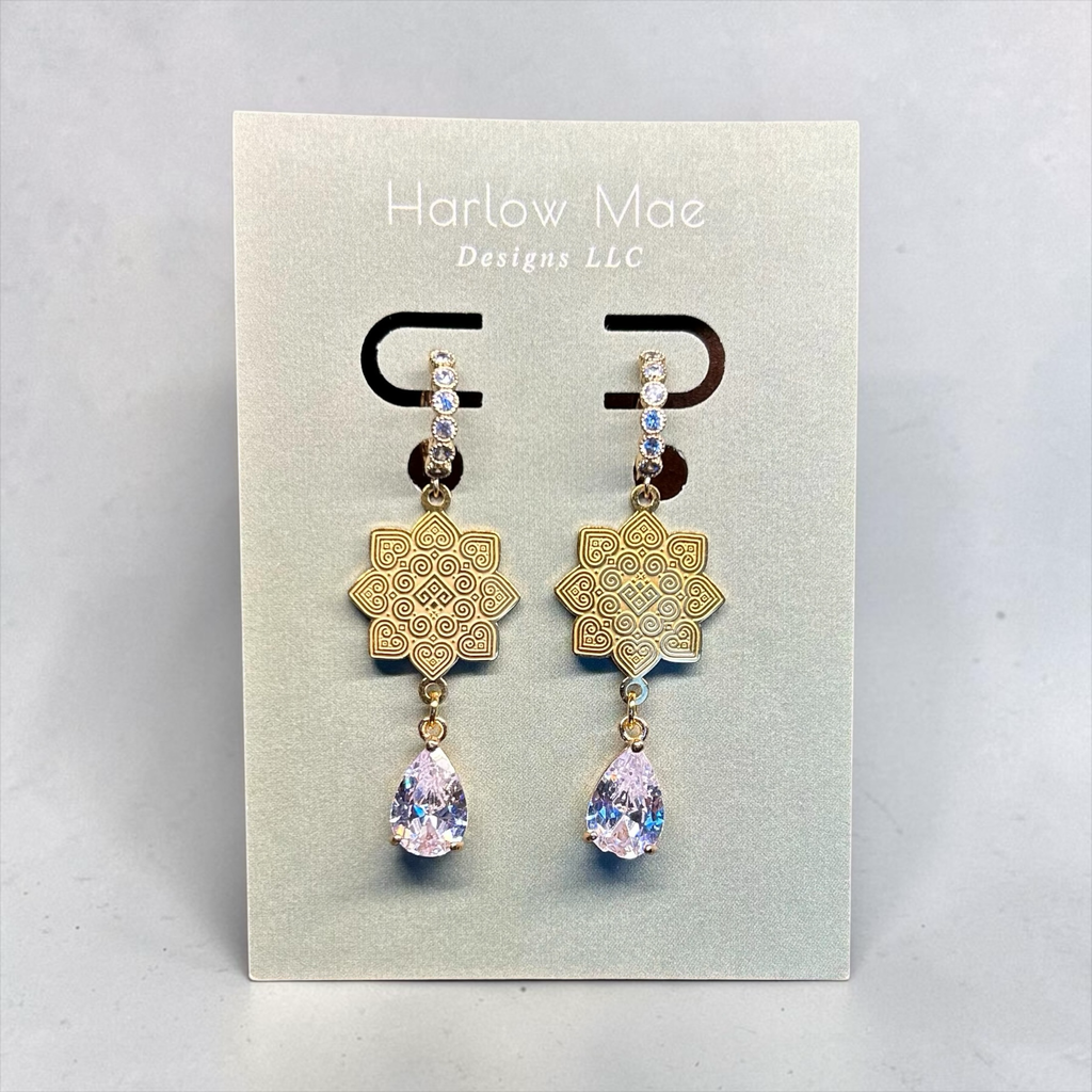 Harlow Mae Designs LLC gold-tone drop earrings with star floral motif and pear-shaped cubic zirconia gemstone.