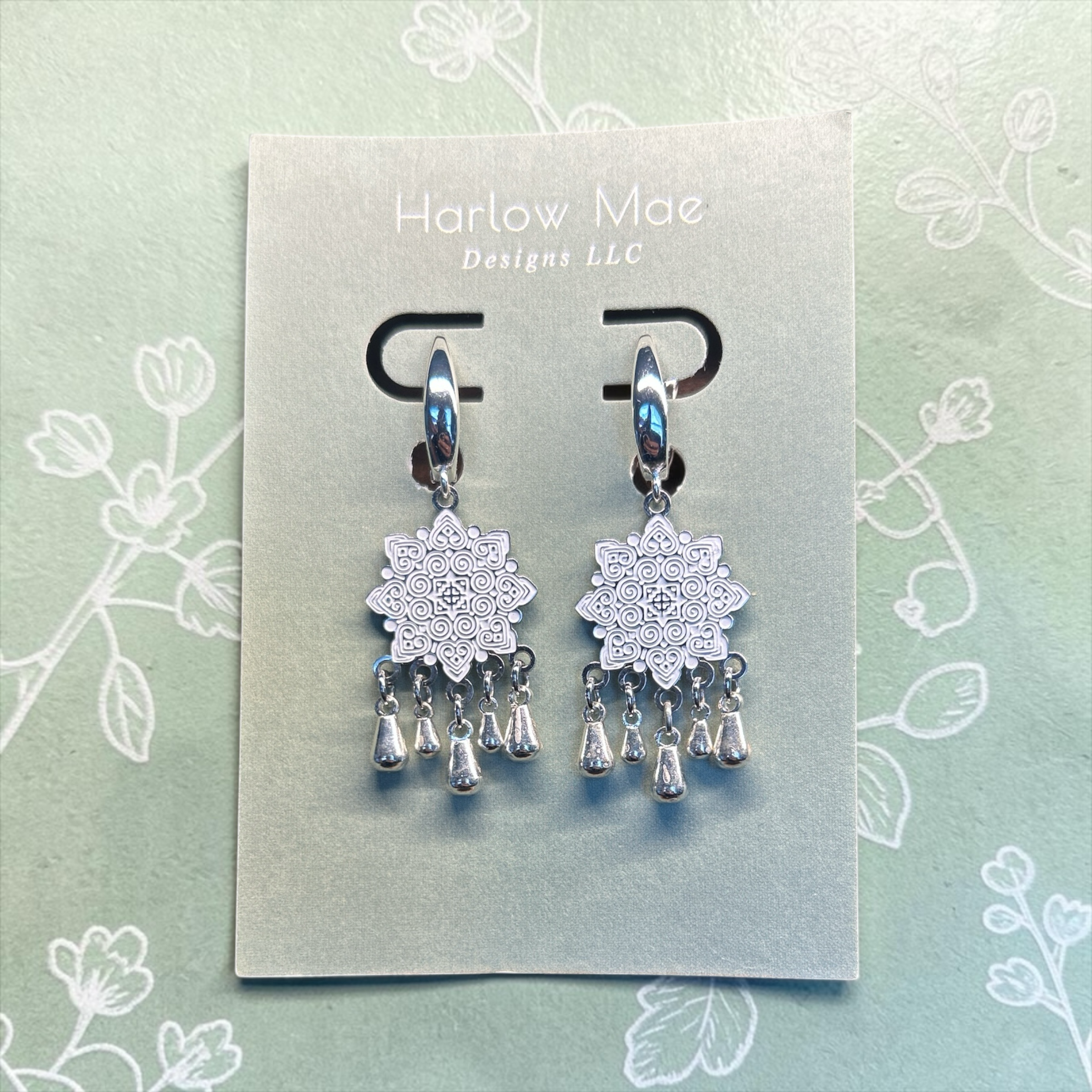 Harlow Mae Designs LLC ornate silver-tone dangle earrings with starburst motif and teardrop bells