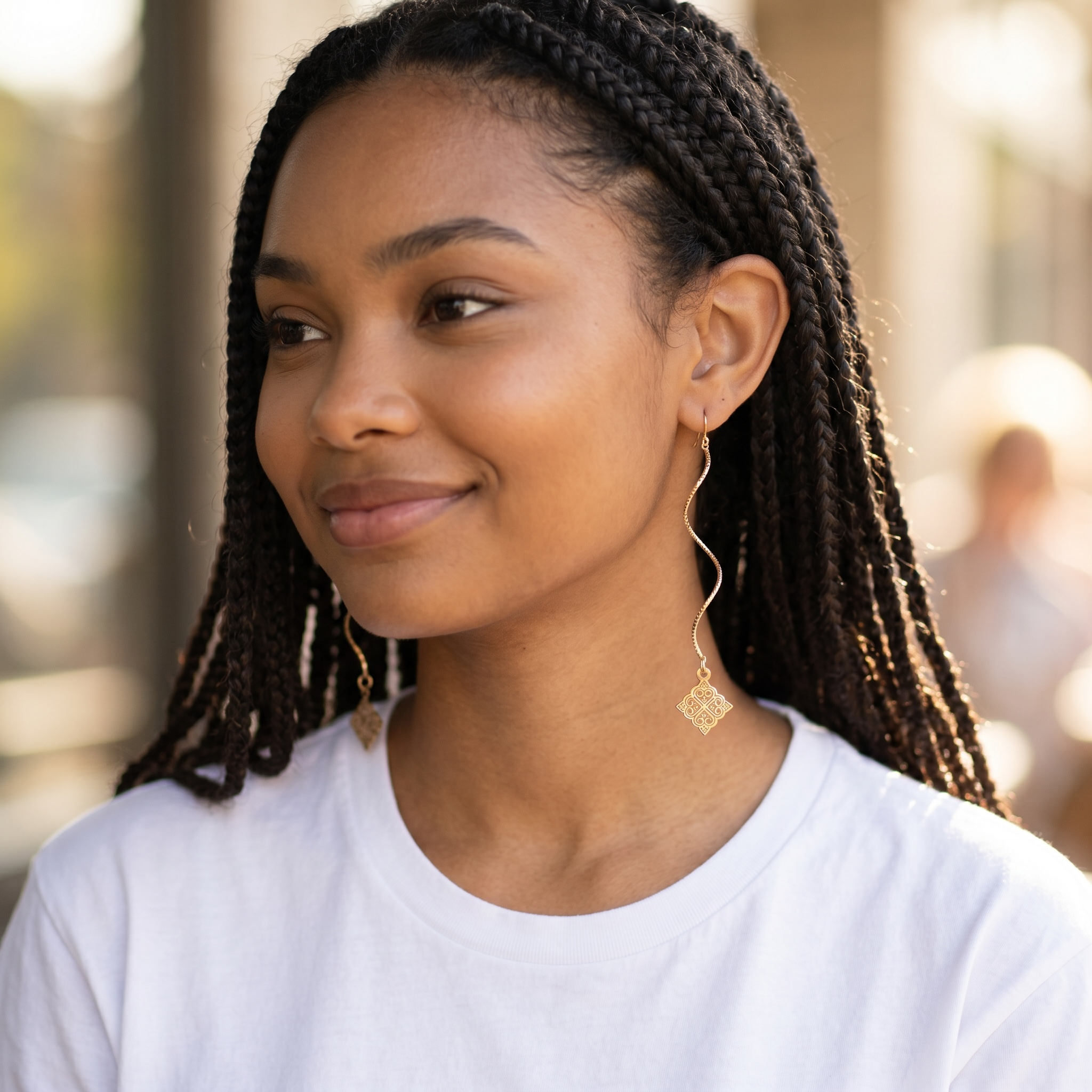 Harlow Mae Designs LLC gold-tone wavy drop earrings with geometric square charms. Model wears white t-shirt.