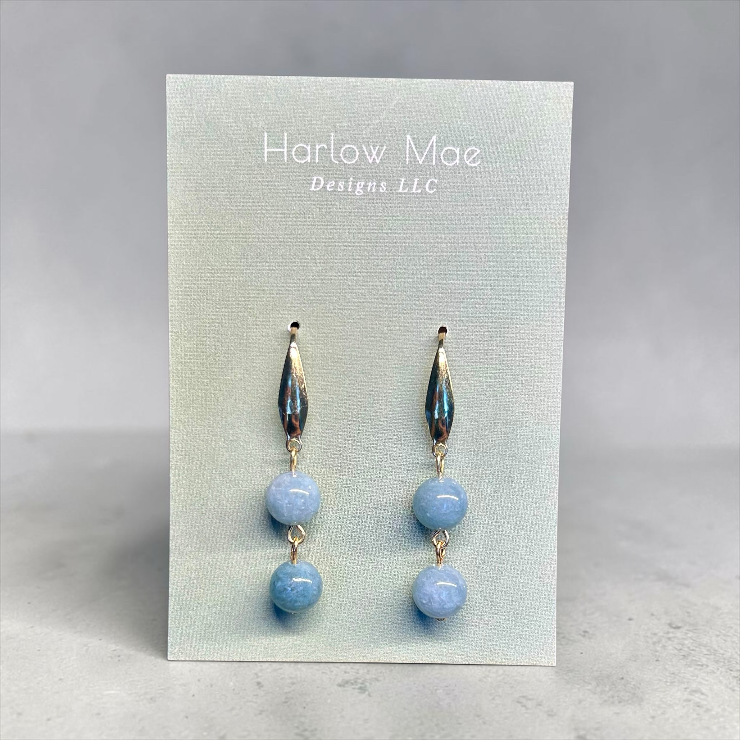 Harlow Mae double stone drop earrings with sky-blue beads and gold-tone metal accents.