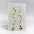 Harlow Mae Designs LLC gold-tone wavy drop earrings with geometric square charms. Lightweight serpentine chain.
