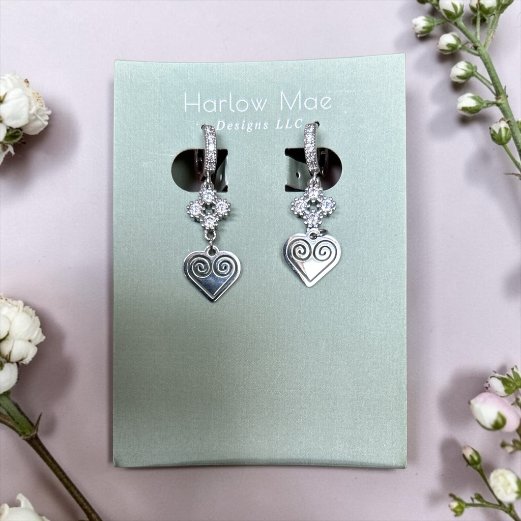 Harlow Mae silver-tone dangle earrings with cubic zirconia clover tops and spiral heart pendants.
